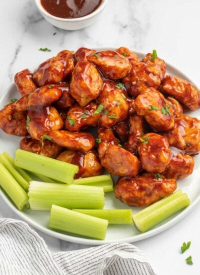 Chicken bites on a plate with celery.