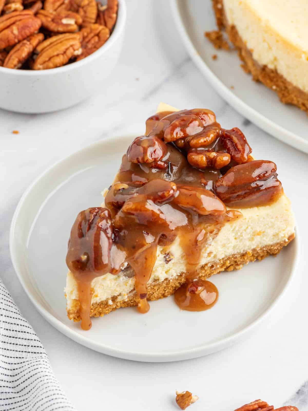 A slice of caramel pecan cheesecake on a plate.