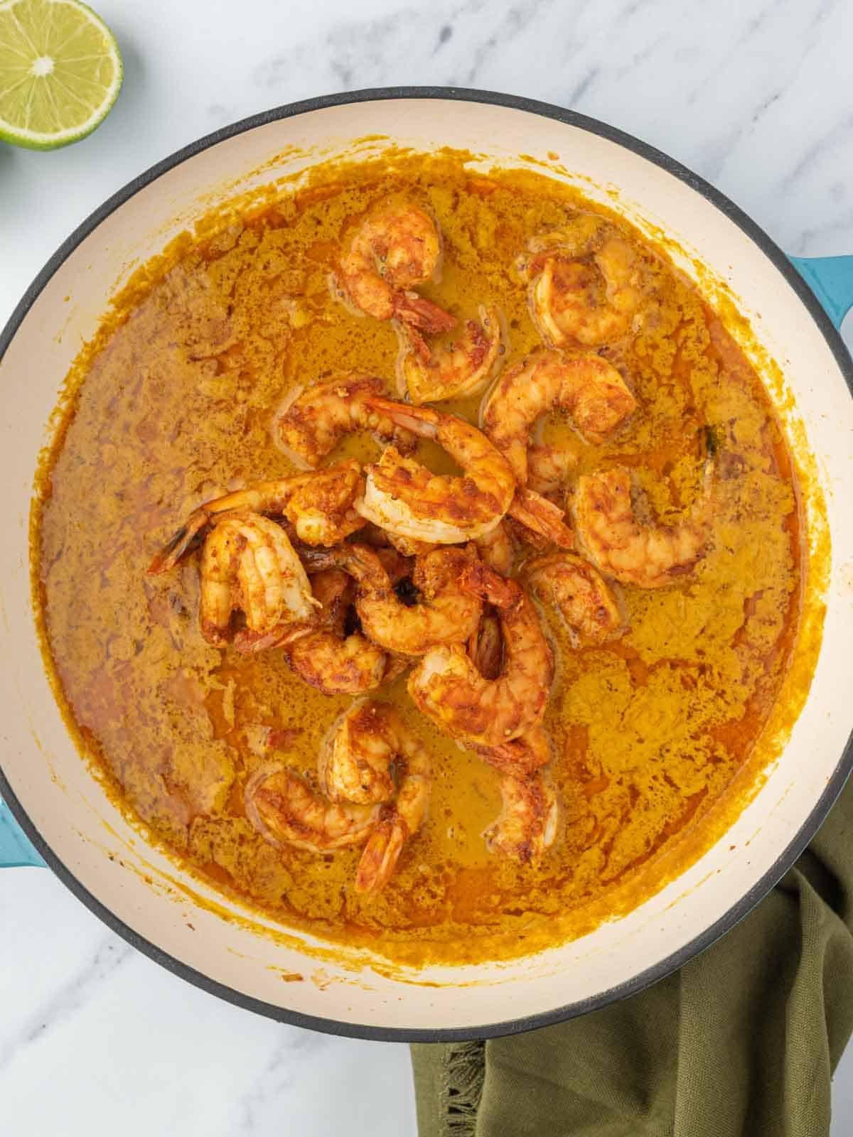 Adding shrimp to the curry sauce.