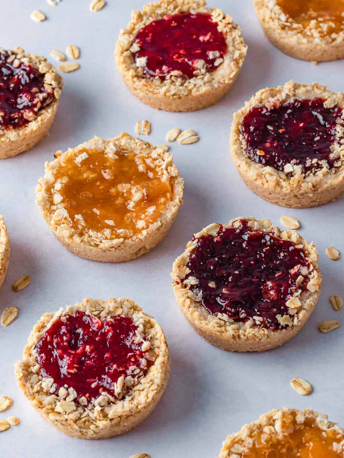 Oatmeal cookies with jam on a tray.