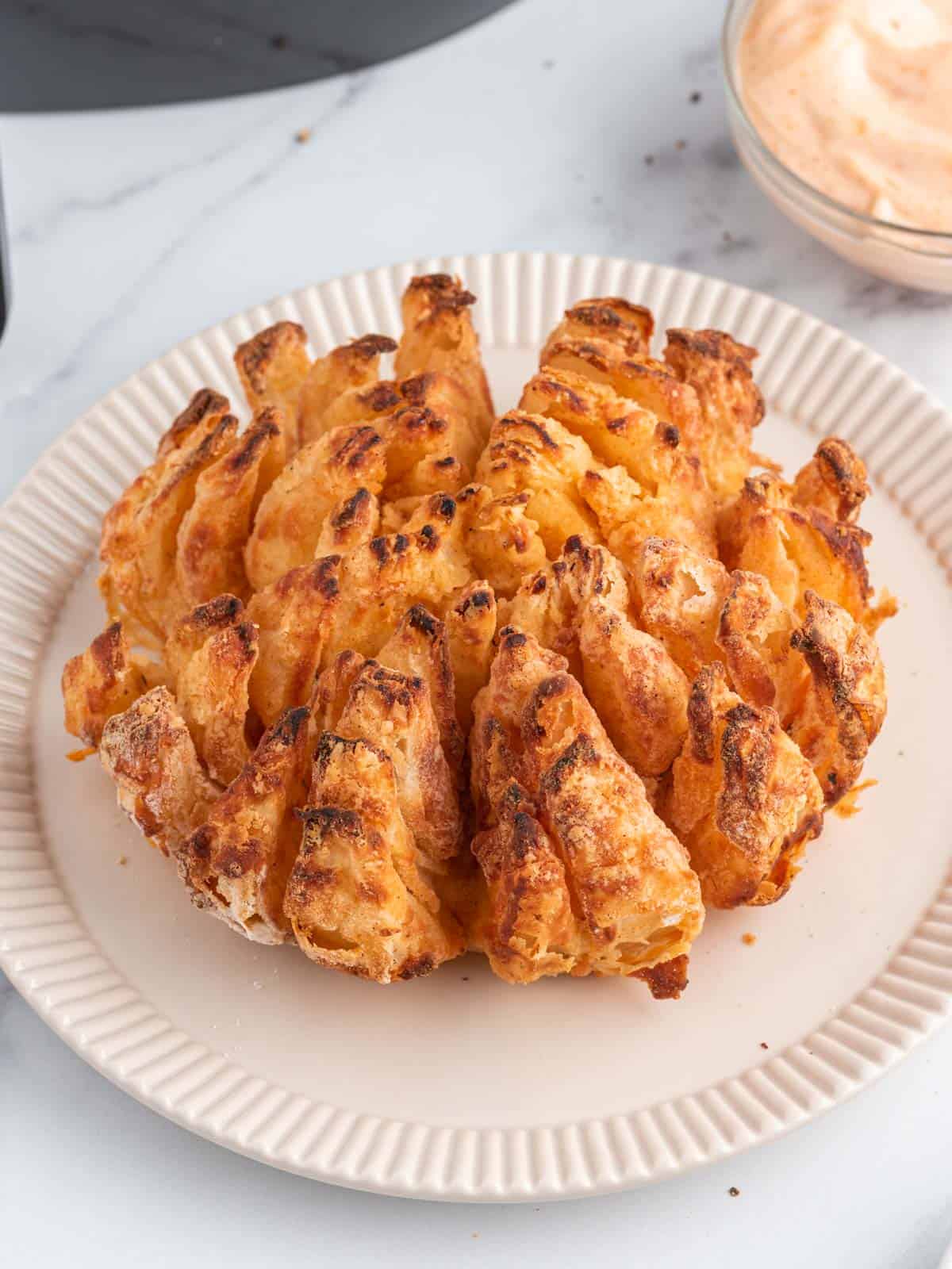 Air fryer blooming onion of a plate.