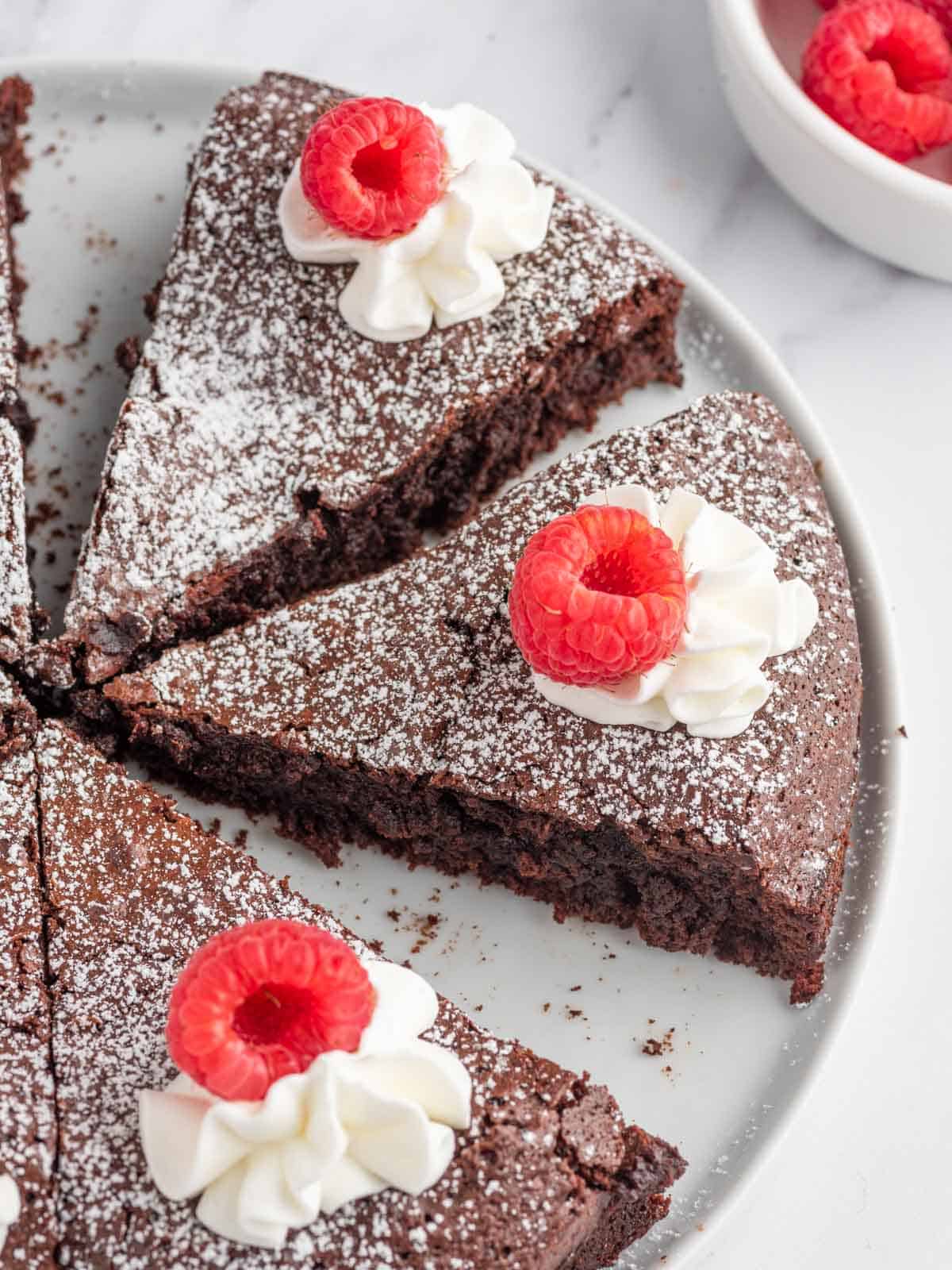 Flourless chocolate torte with whipped cream and raspberries.