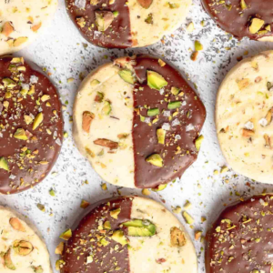 Buttery pistachio cookies dipped in dark chocolate and topped with chopped nuts and salt flakes.