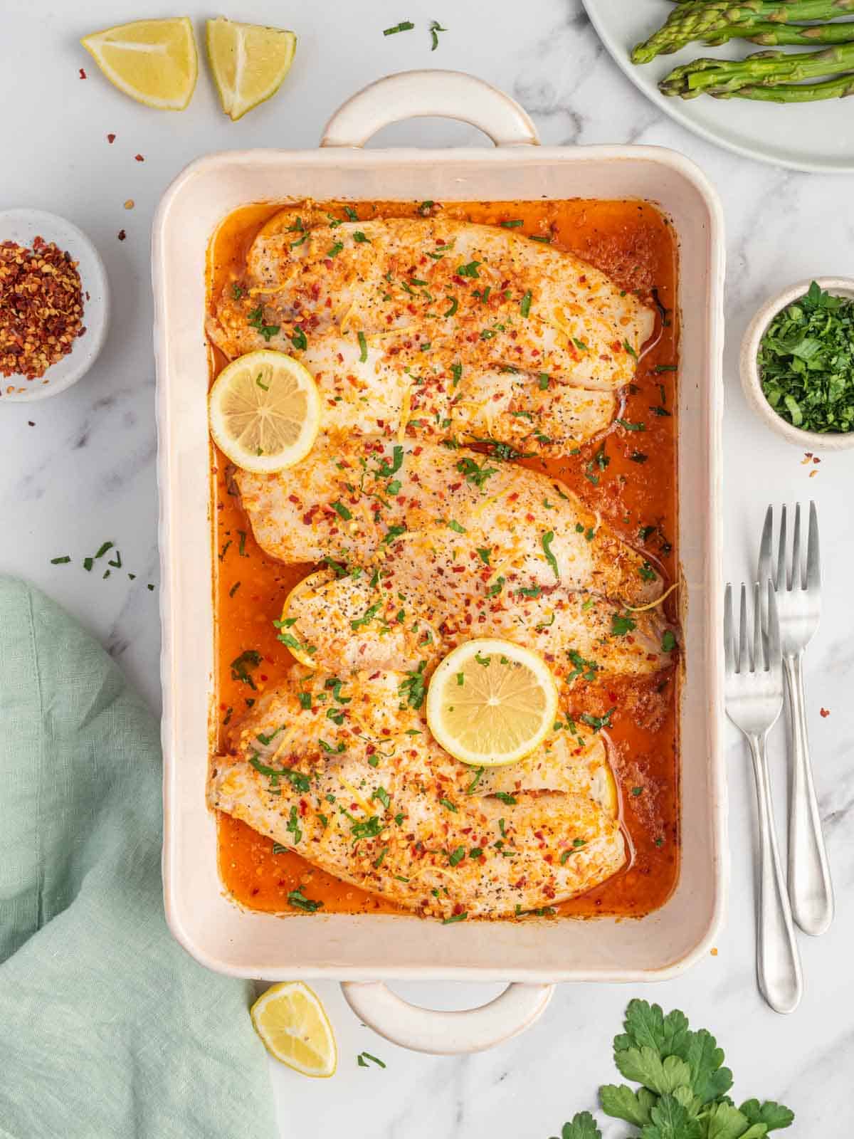 Finished easy oven baked tilapia recipe in a baking dish with forks.