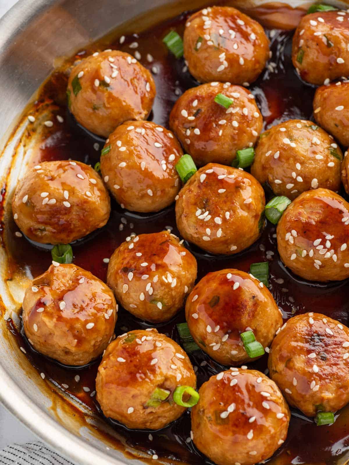 A pan of meatballs with teriyaki sauce.