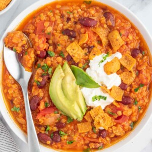 Vegan bean chili topped with fritos, avocado and vegan sour cream.