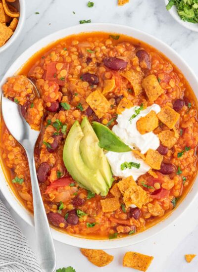 Vegan bean chili topped with fritos, avocado and vegan sour cream.