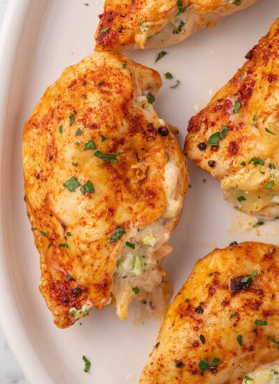 Close up of broccoli stuffed chicken on a platter.