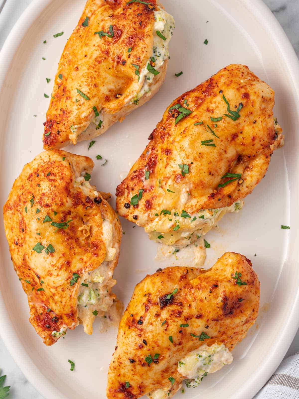 Several pieces of air fryer chicken breast rest on a plate.