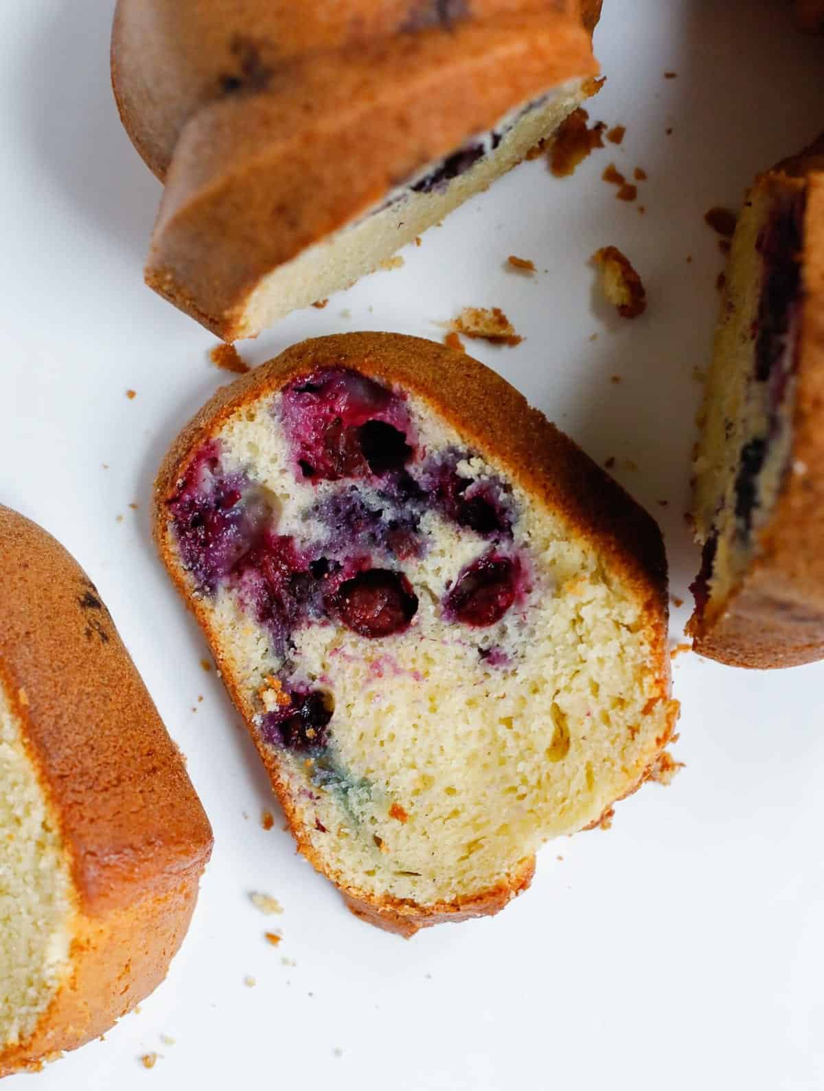 a slice of blueberry cake next to the bundt cake.