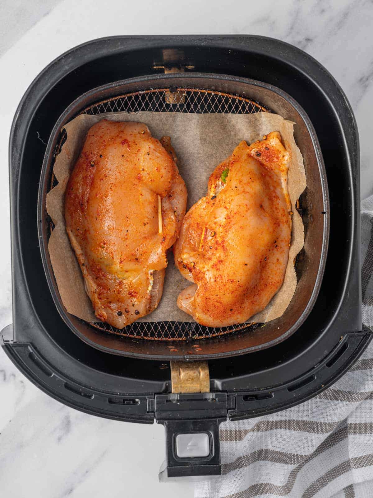 Raw stuffed chicken breast in an air fryer.