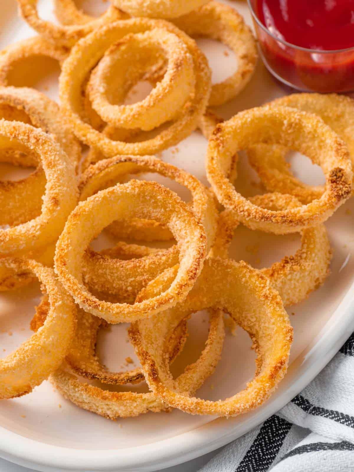 Closeup of panko crusted onion rings on a plate.