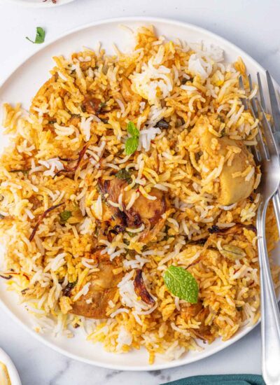 2 forks rest on a a plate of homemade chicken biryani.en