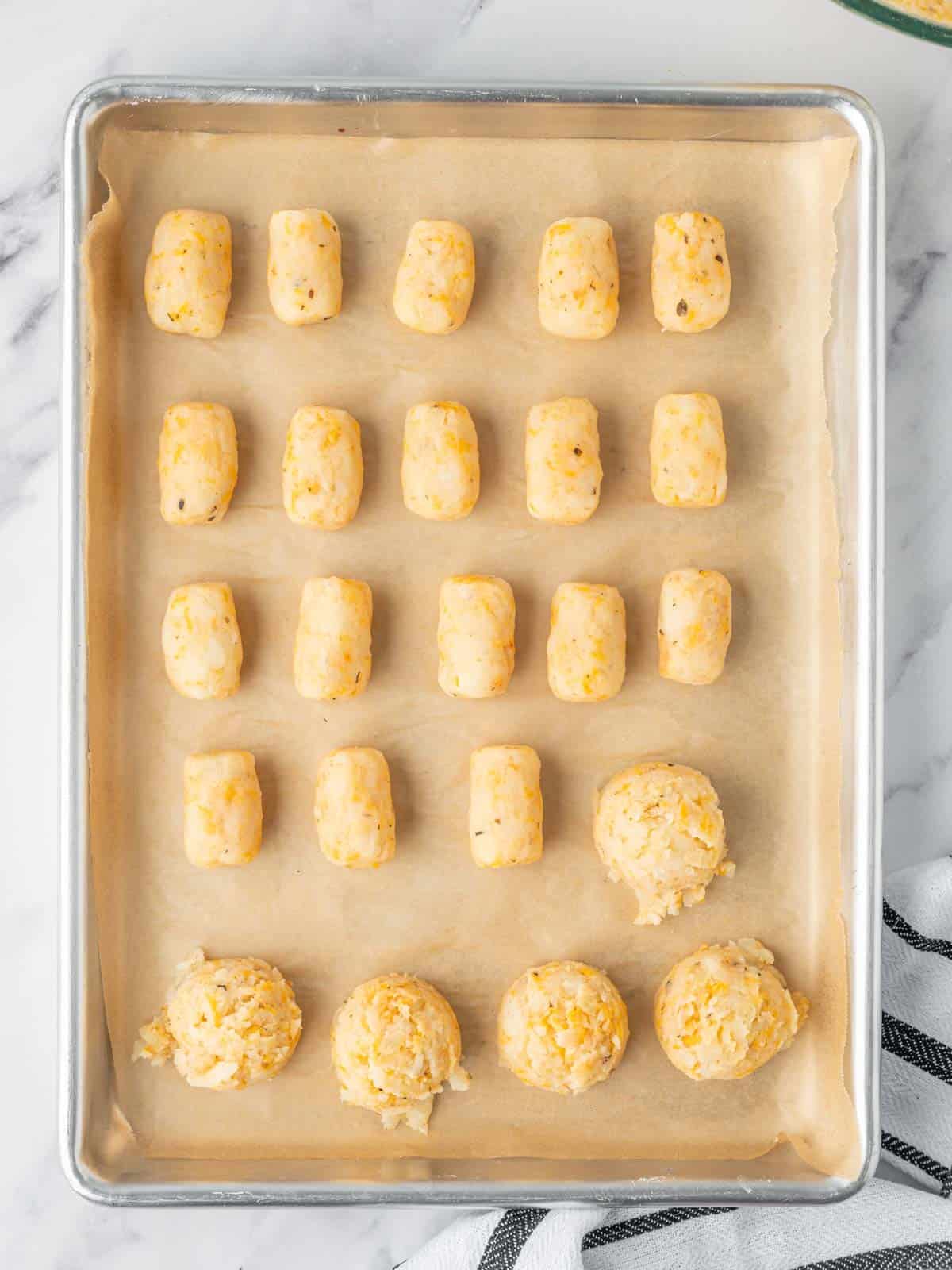 Scoops of potato and cheese mixture are formed into tater tots.
