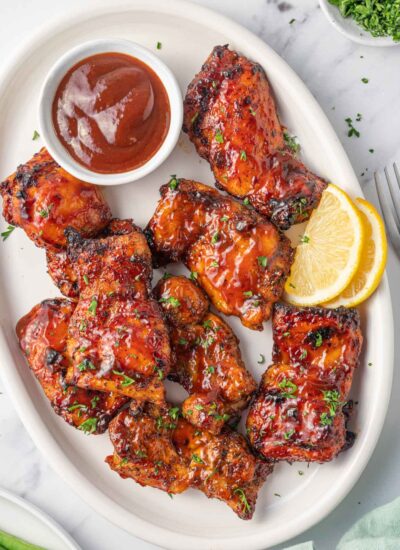 Air fryer bbq chicken on a plate with extra barbecue sauce.