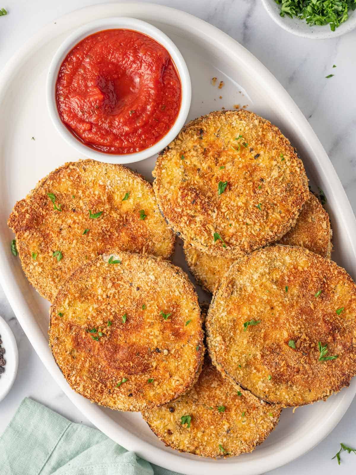 A platter of air fried eggplant with marinara.