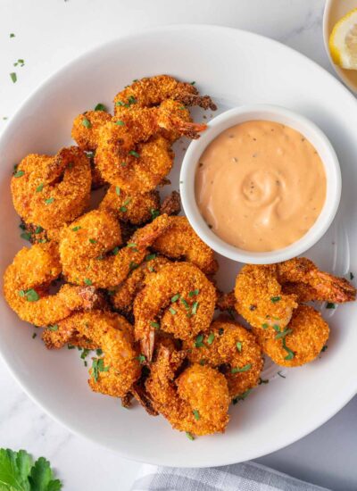 A platter of crunchy keto breaded shrimp and a bowl of dipping sauce.