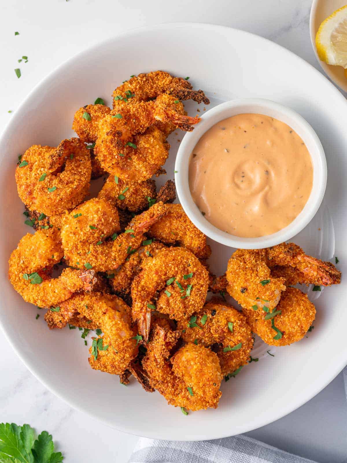 A platter of crunchy keto breaded shrimp and a bowl of dipping sauce.