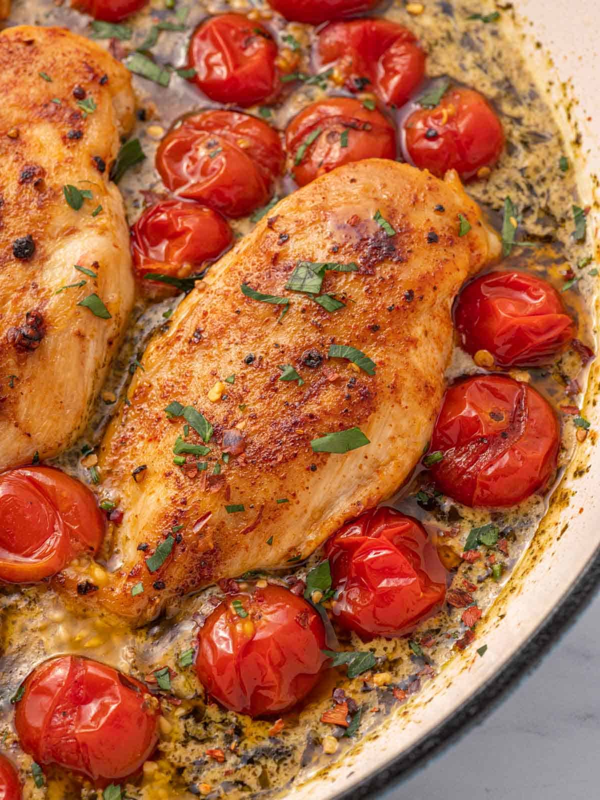 Closeup of skillet pesto chicken.