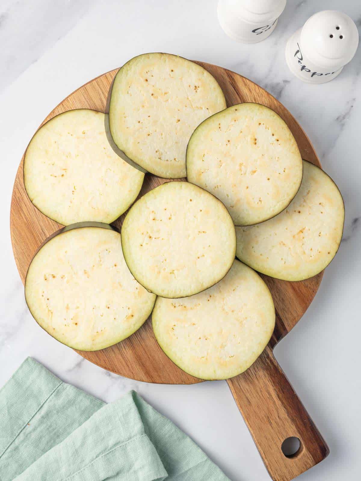 Slices of eggplant on a board.