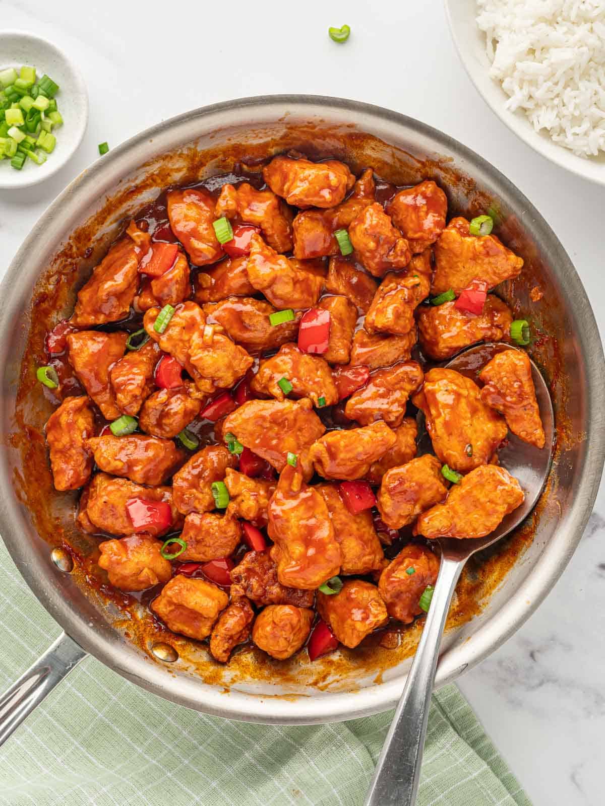 A spoon lifts a serving of Indo-chinese chicken recipe.