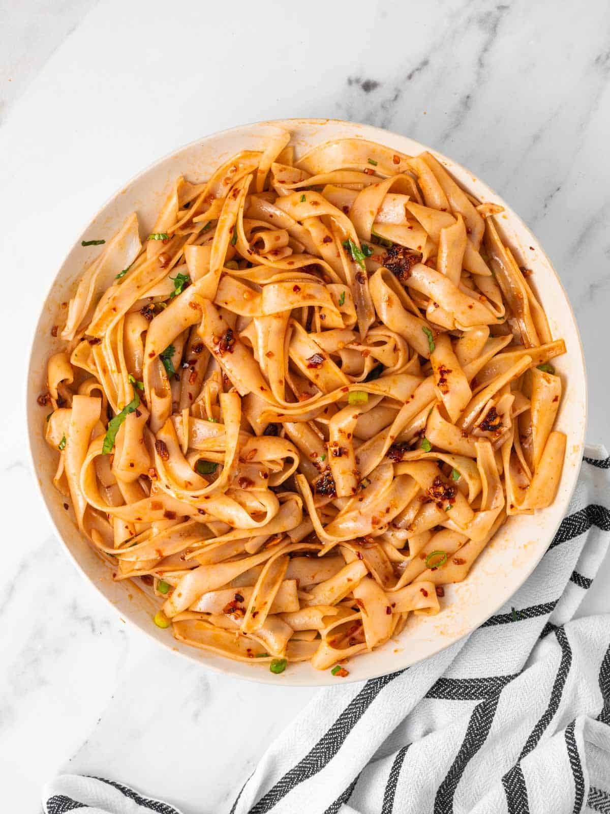 A bowl of chili oil noodles with garlic.