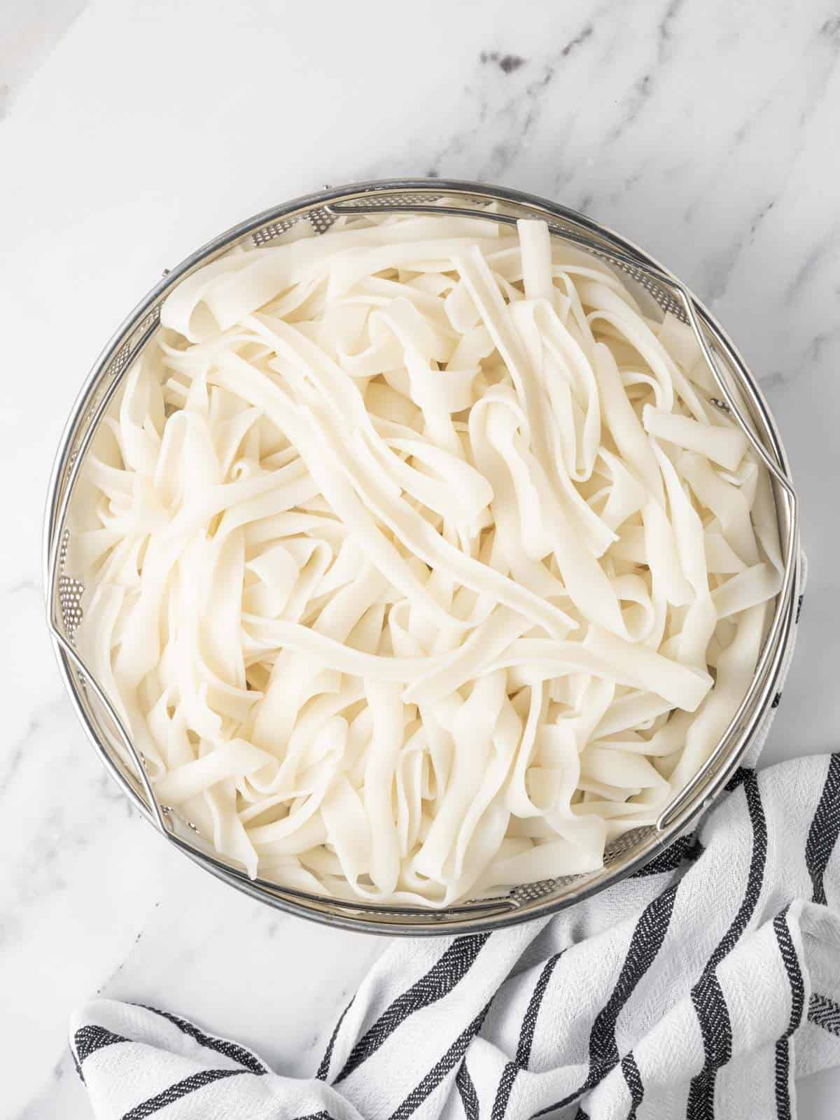 Cooked noodles in a colander.