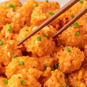 A bowl of baked bang bang cauliflower with chopsticks.
