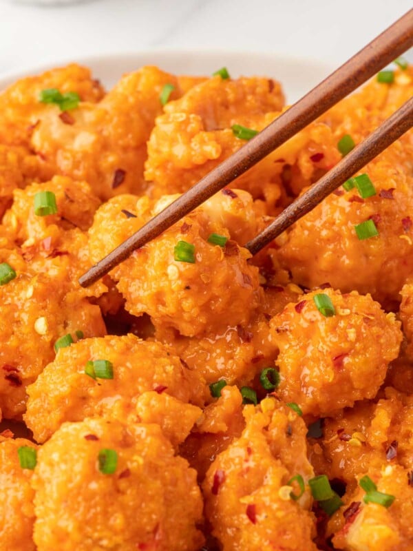 A bowl of baked bang bang cauliflower with chopsticks.