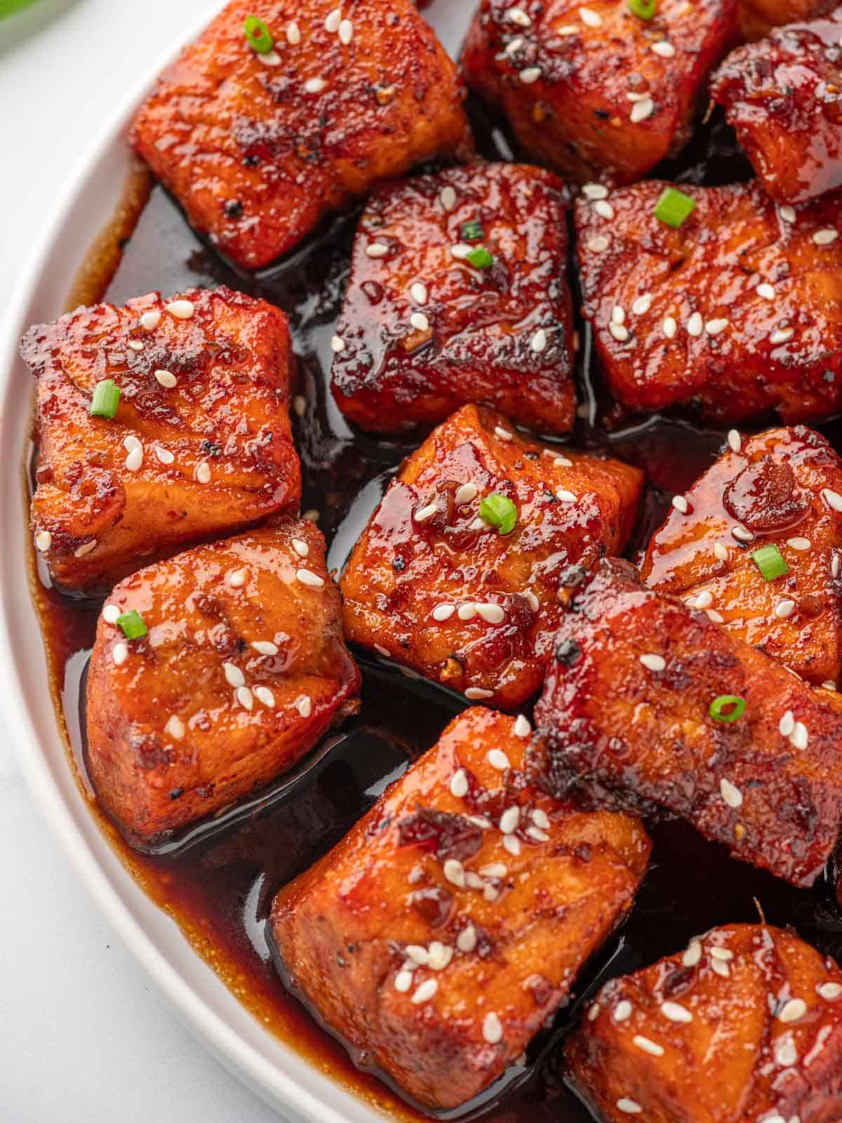 Close up of glazed salmon bites with sesame seeds.