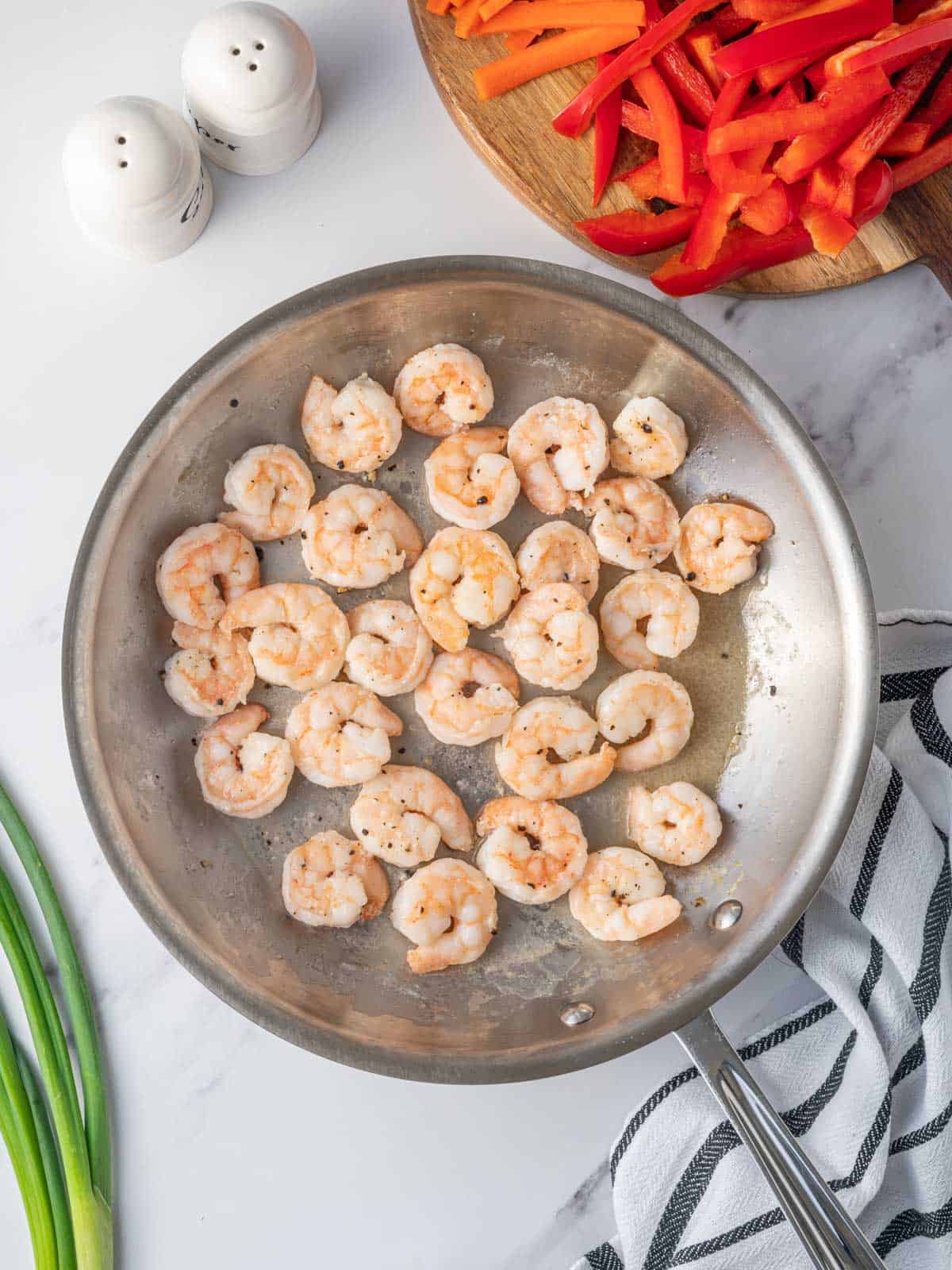 Shrimp sautéing in a skillet.