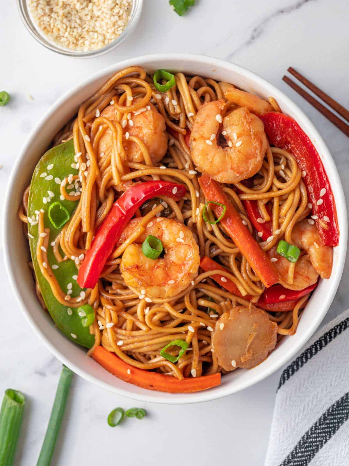 A bowl of sweet and savory lo mein with shrimp,