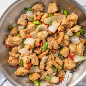 A spoon serves chinese chicken recipe from a wok.