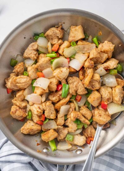 A spoon serves chinese chicken recipe from a wok.