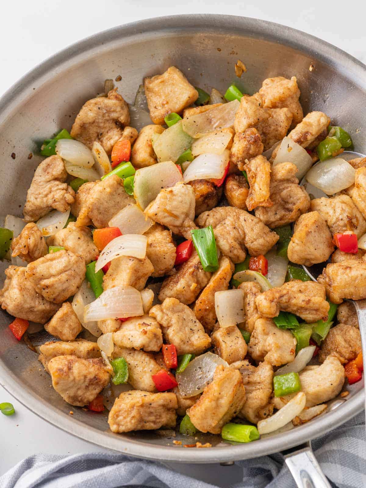 Crispy salt and pepper chicken in a skillet.