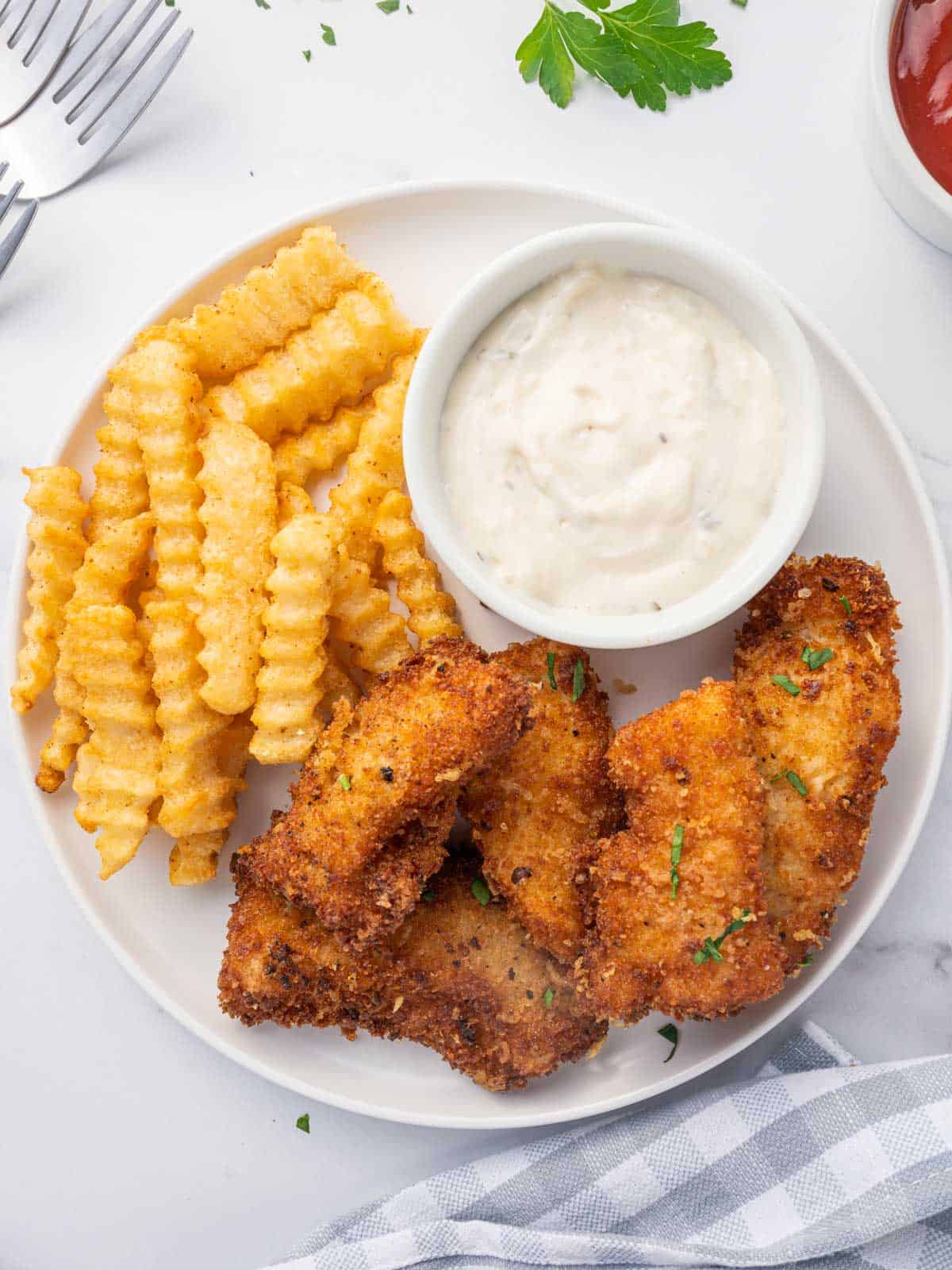 Gluten free fish with a side of fries and dip.