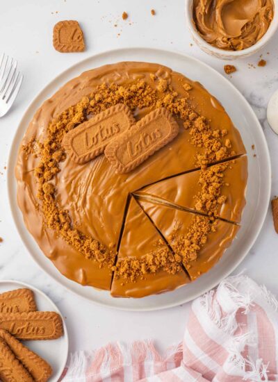 A whole biscoff cheese cake is cut into slices.