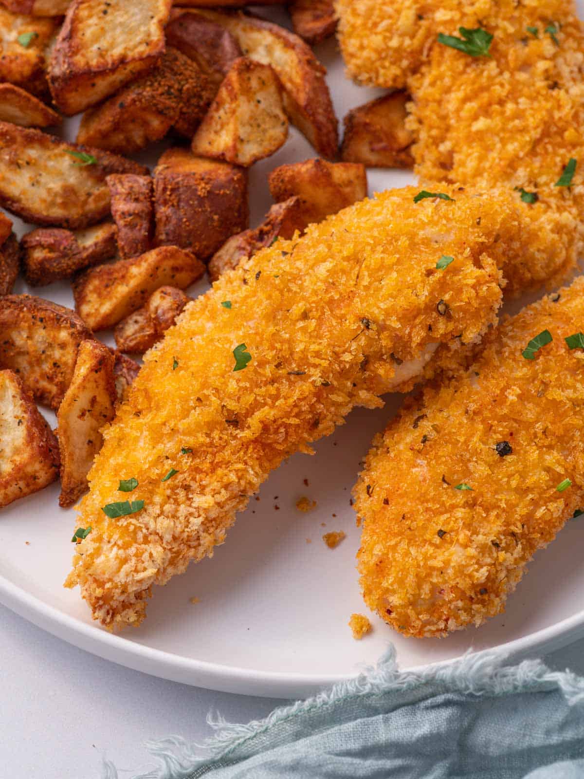 Crispy panko chicken on a plate with roasted potatoes.