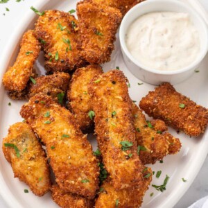 A plate of crispy fried fish with dip.