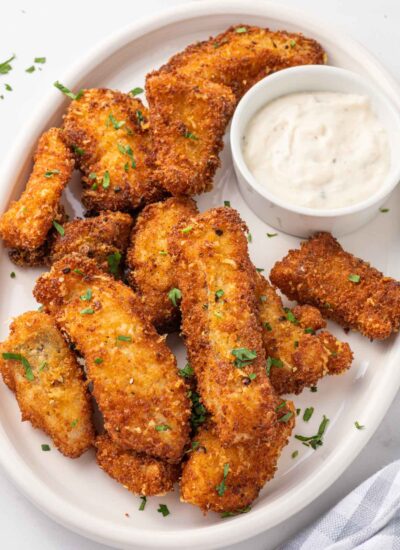 A plate of crispy fried fish with dip.