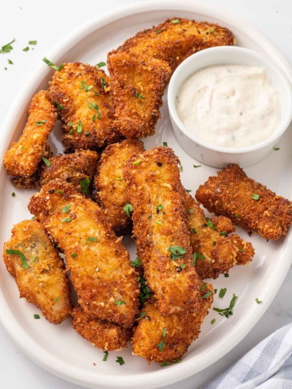 A plate of crispy fried fish with dip.