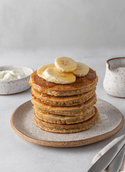 A stack of protein pancakes topped with banana slices.