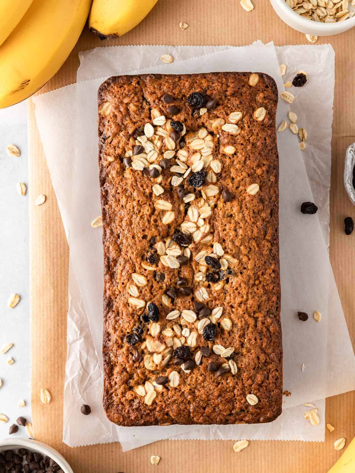 A loaf of oatmeal banana bread on parchment paper.