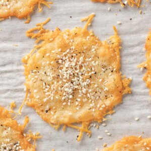 Parmesan cheese chips topped with seasoning on a tray.