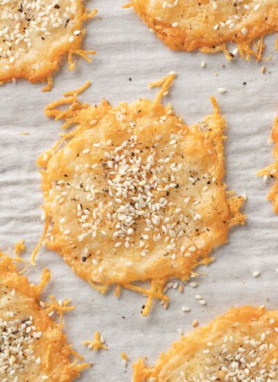 Parmesan cheese chips topped with seasoning on a tray.