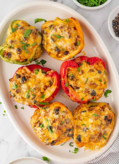 A plate with six stuffed peppers.