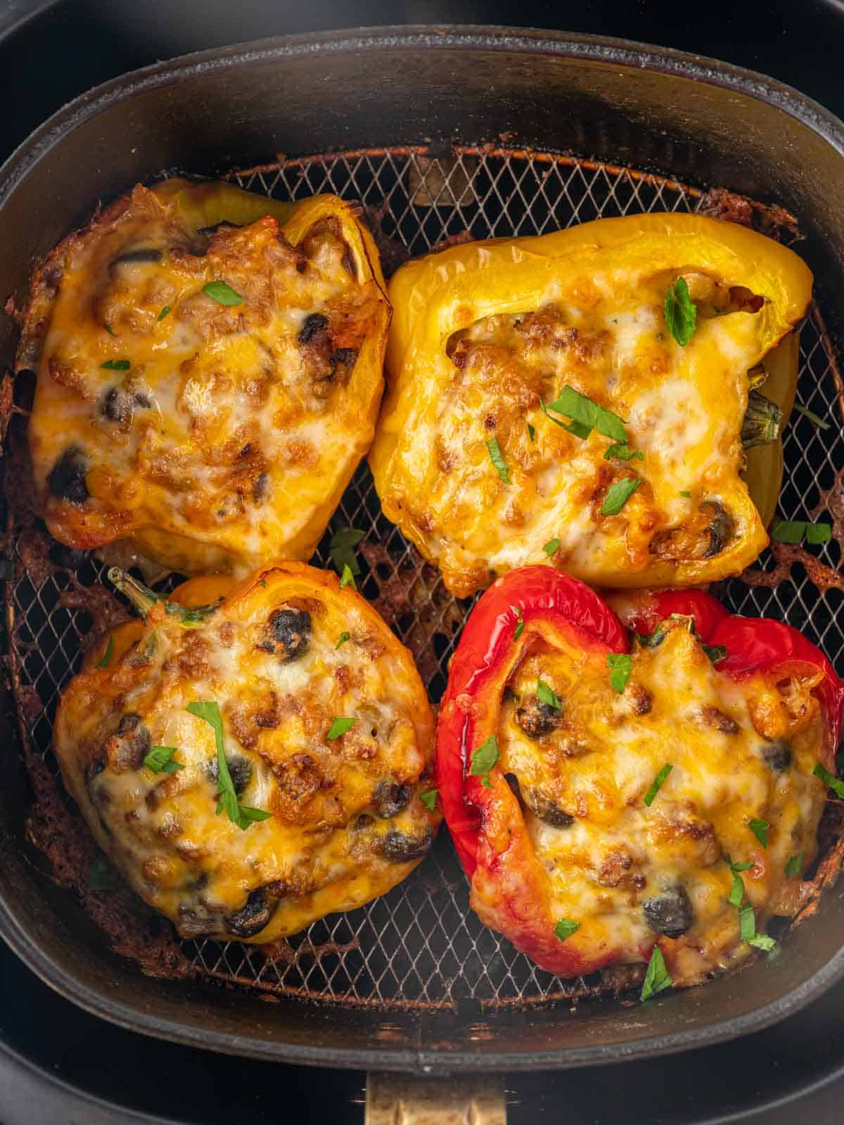 Cheese melted over stuffed peppers in air fryer.