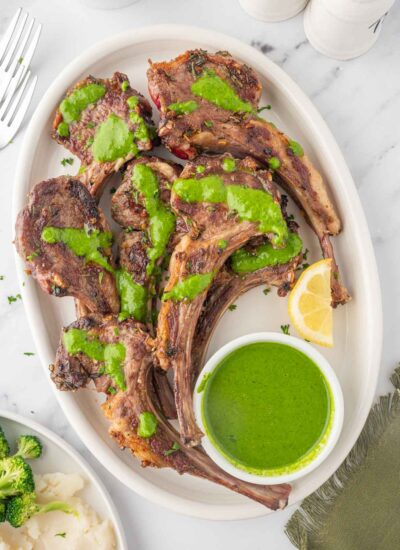 A platter of lamb chops with mint herb sauce.