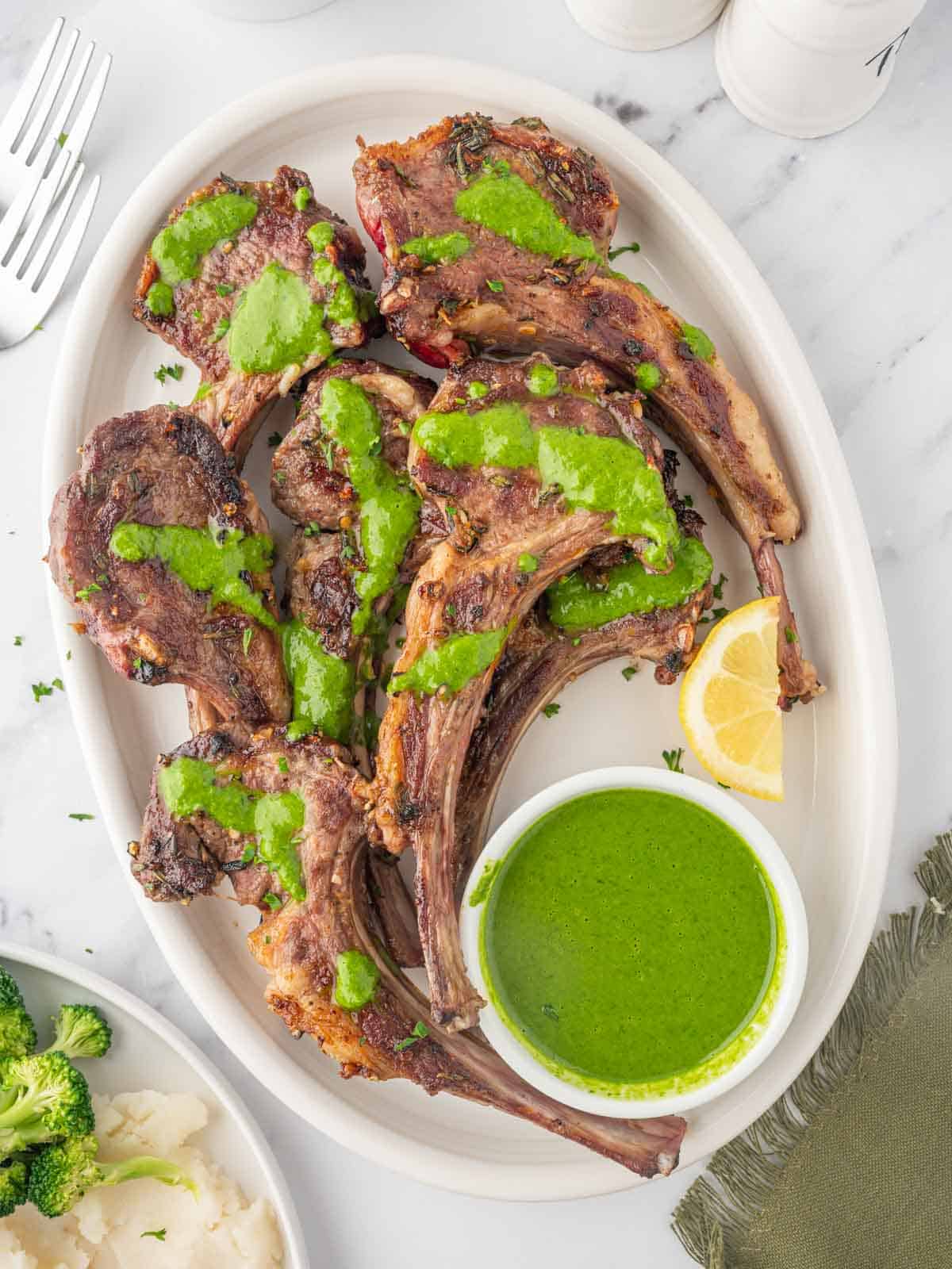 A platter of lamb chops with mint herb sauce.