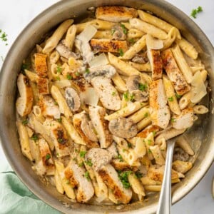 A spoon scoops a portion of garlic parm chicken pasta.